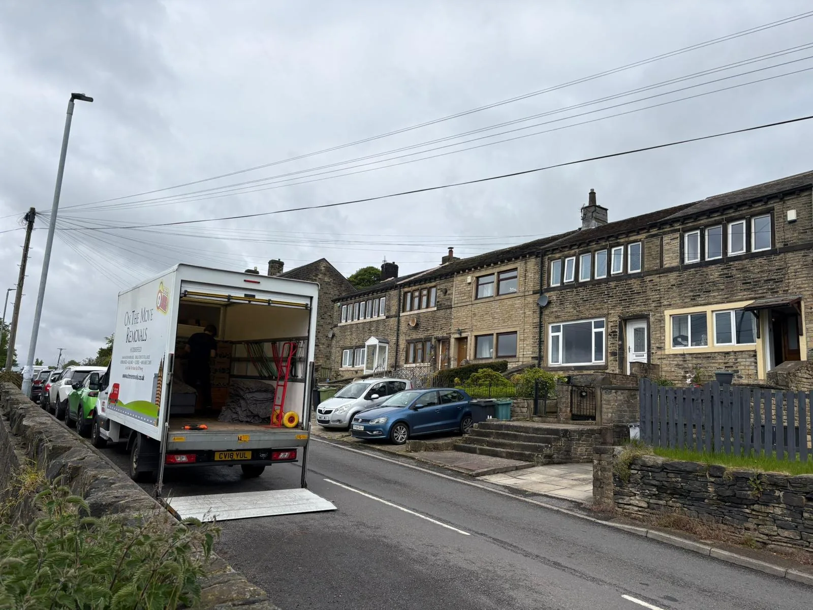 On The Move Removals loading a Luton van on a residential street in Waterloo, Huddersfield