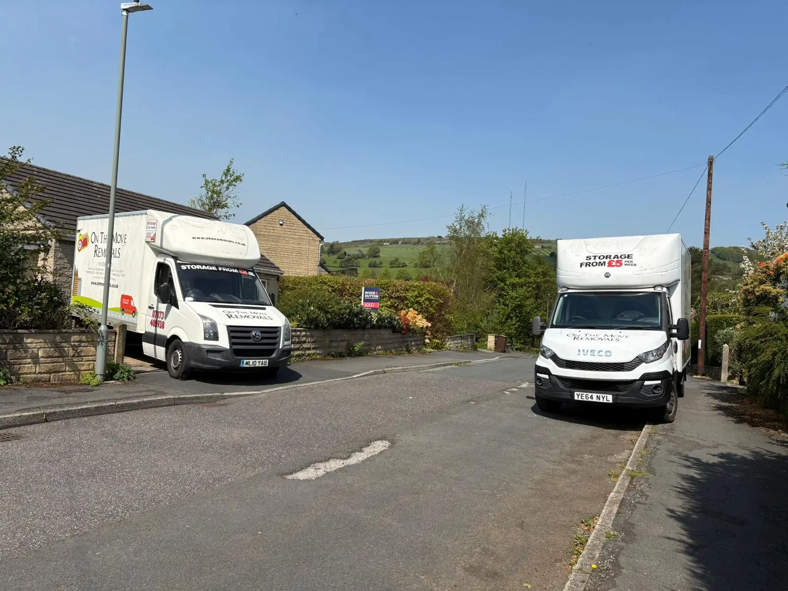 Two On The Move Removals vans on a residential street ready for a Wakefield removal job