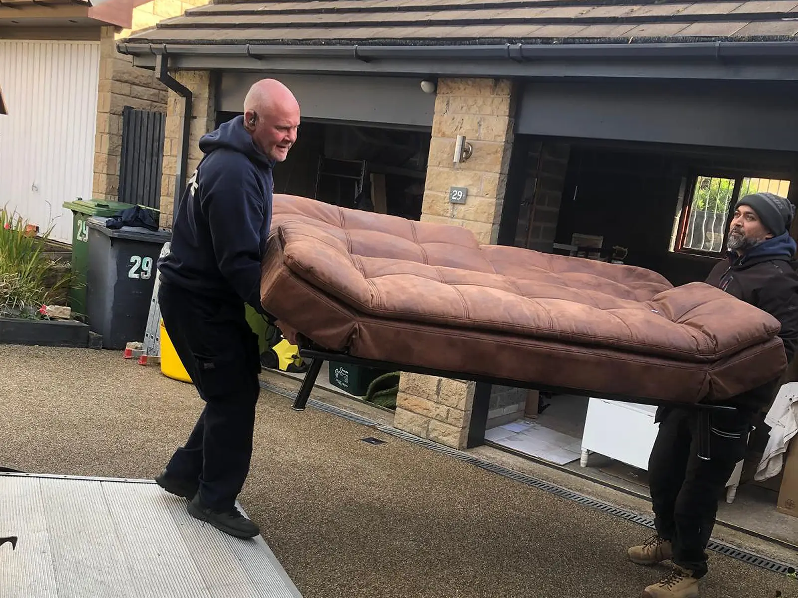 Carrying sofa onto removal van