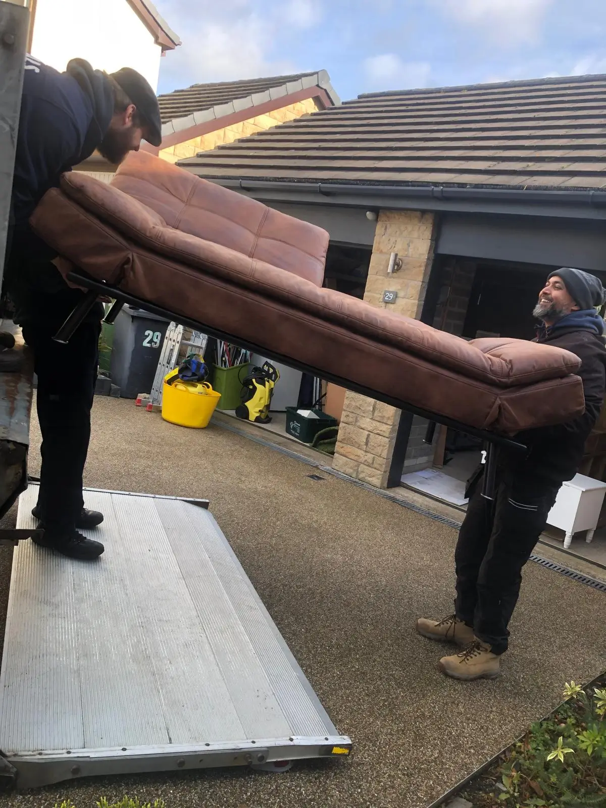 Team carrying sofa bed to van